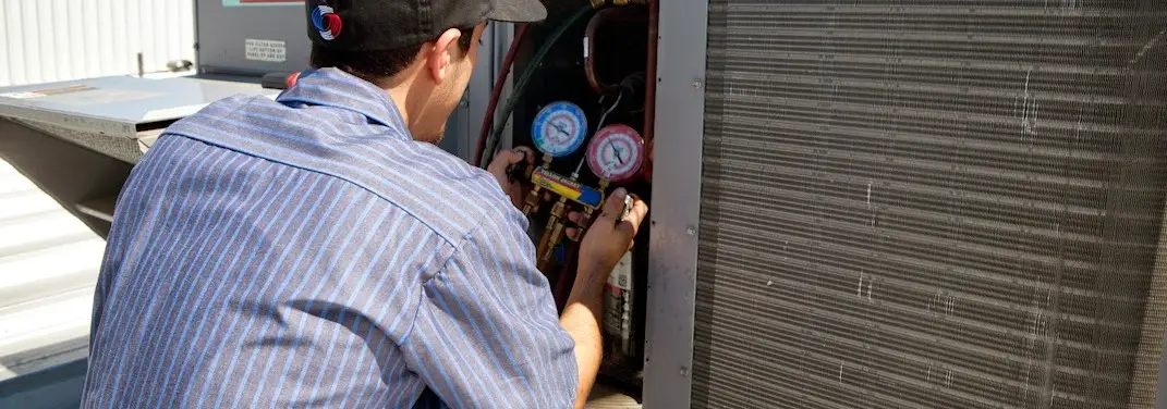HVAC technician servicing a condenser unit in Durham